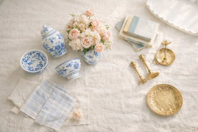 Decorative items including blue and white ceramic bowls, a vase with flowers, and gold accents on a textured surface.